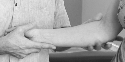 Der Therapeut arbeitet am Arm eines Patienten