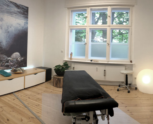 Blick in den Behandlungsraum auf die Behandlungsbank der Praxis für Osteopathie Berlin